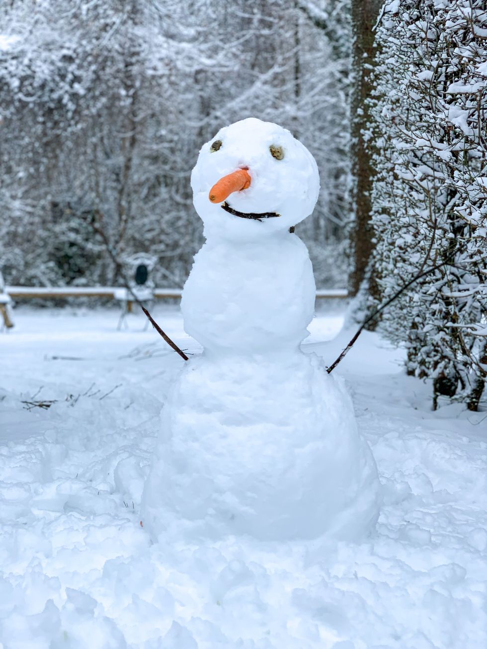 Snowman on snow covered ground during daytime.