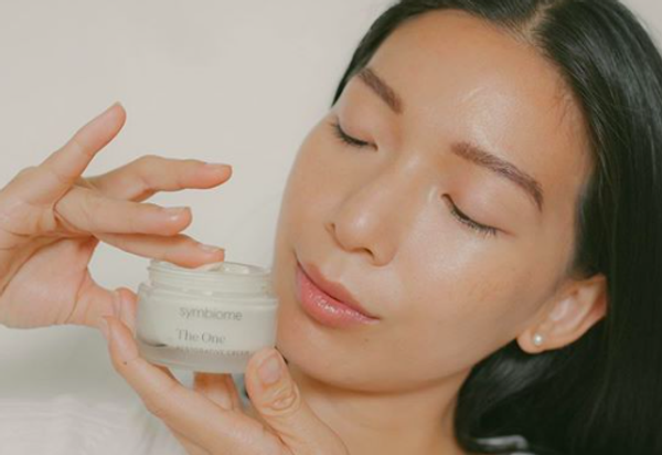 someone tapping finger in jar labeled "symbiome The One"