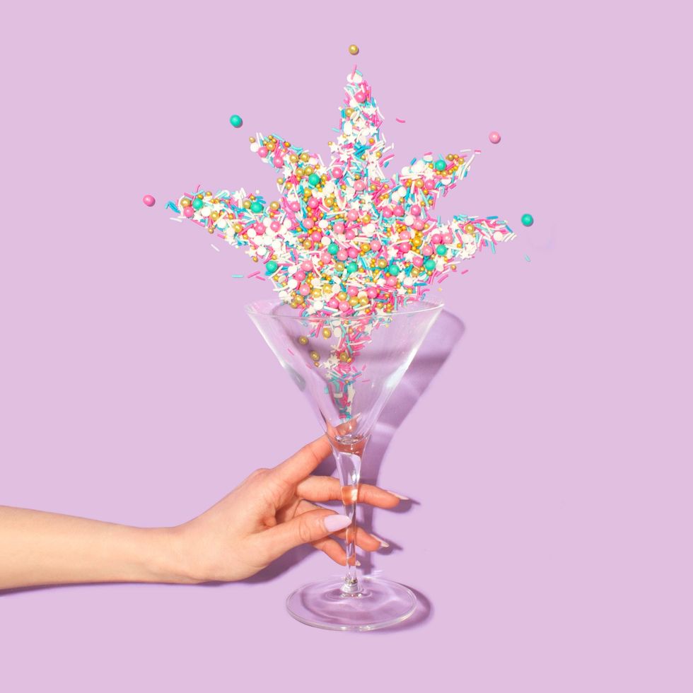 sprinkles on martini glass held by a hand