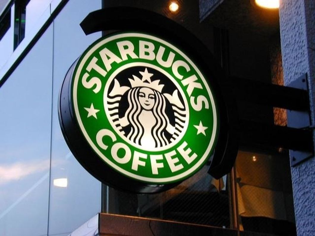 Starbucks logo sign on glass wall