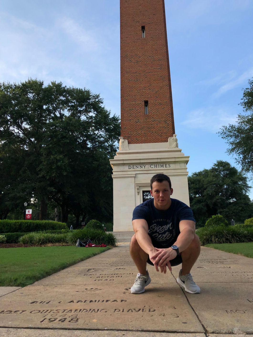 Student kneeling in front of Denny Chimes
