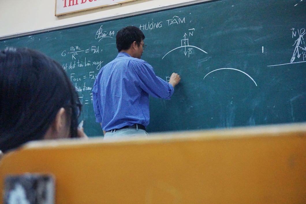 teacher writing on chalk board