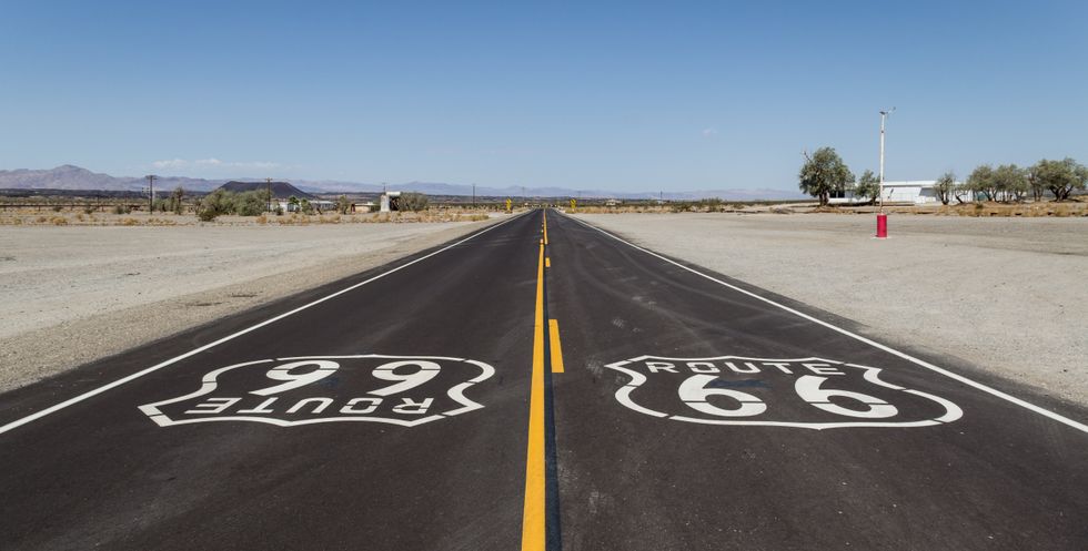 This is an image of a roadway in the desert with the Route 66 emblems.