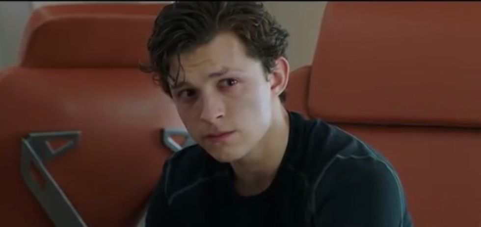 Tom Holland as Peter Parker looking defeated past the camera.