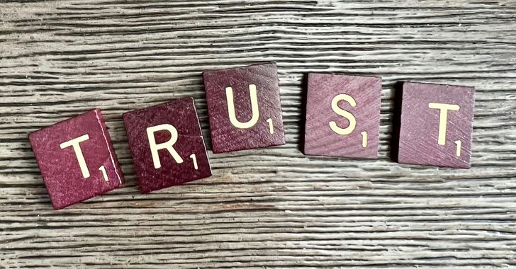 trust spelled with wooden letter blocks on a table