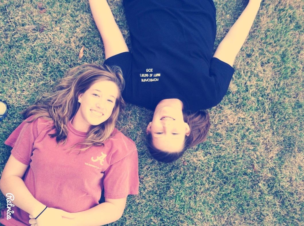 two girls laying in the grass