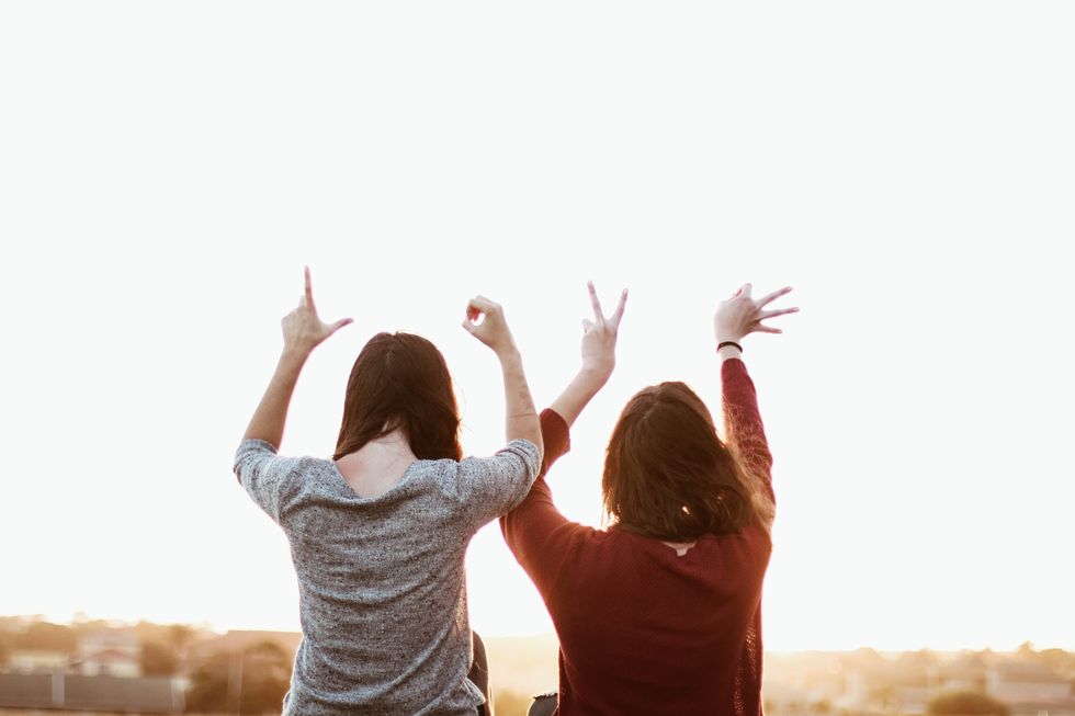 Two girls spelling love