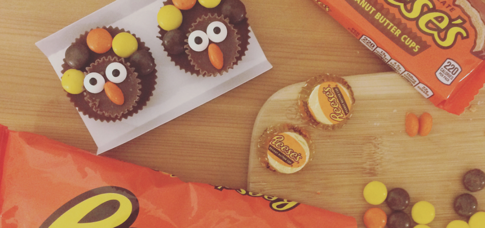 two peanut butter cups with eyes and a nose made out of candy to look like turkeys
