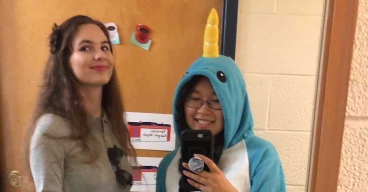 Two women dressed for halloween pose in front of mirror.