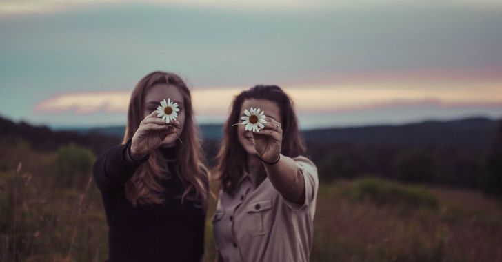 two women holding flowers