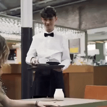Waiter serving a coffee and spiling it over the table