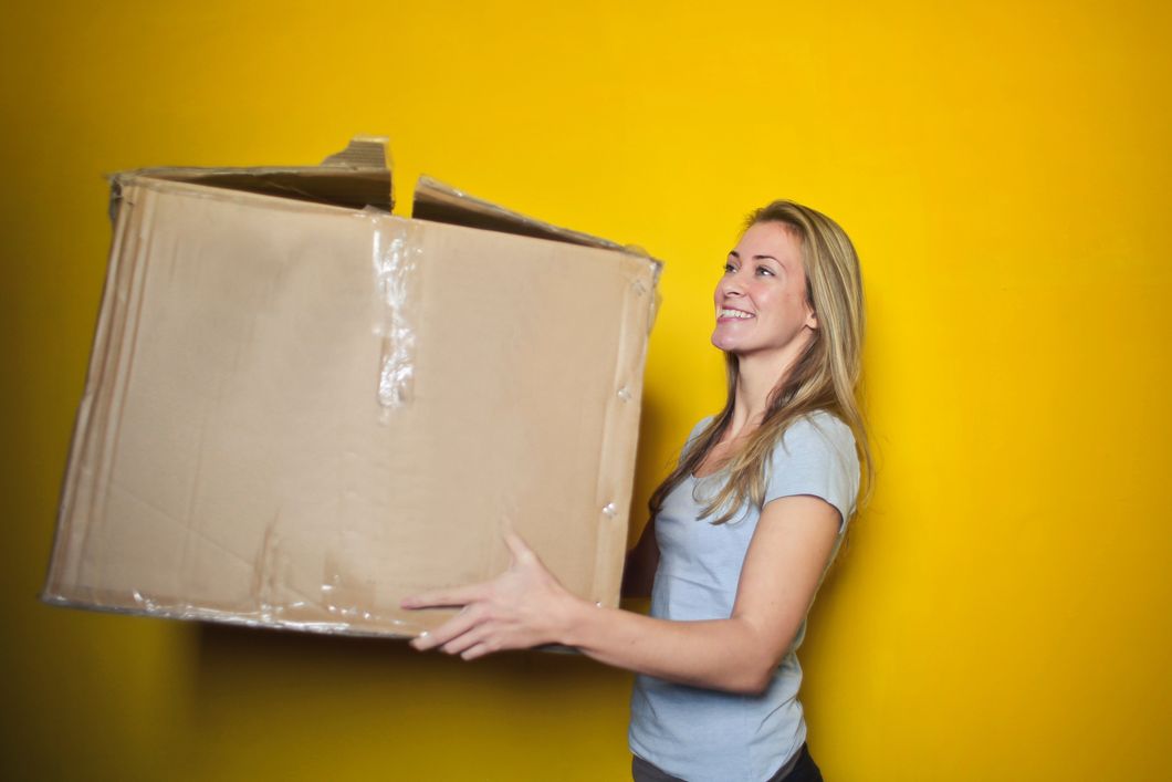 woman carrying a box while moving