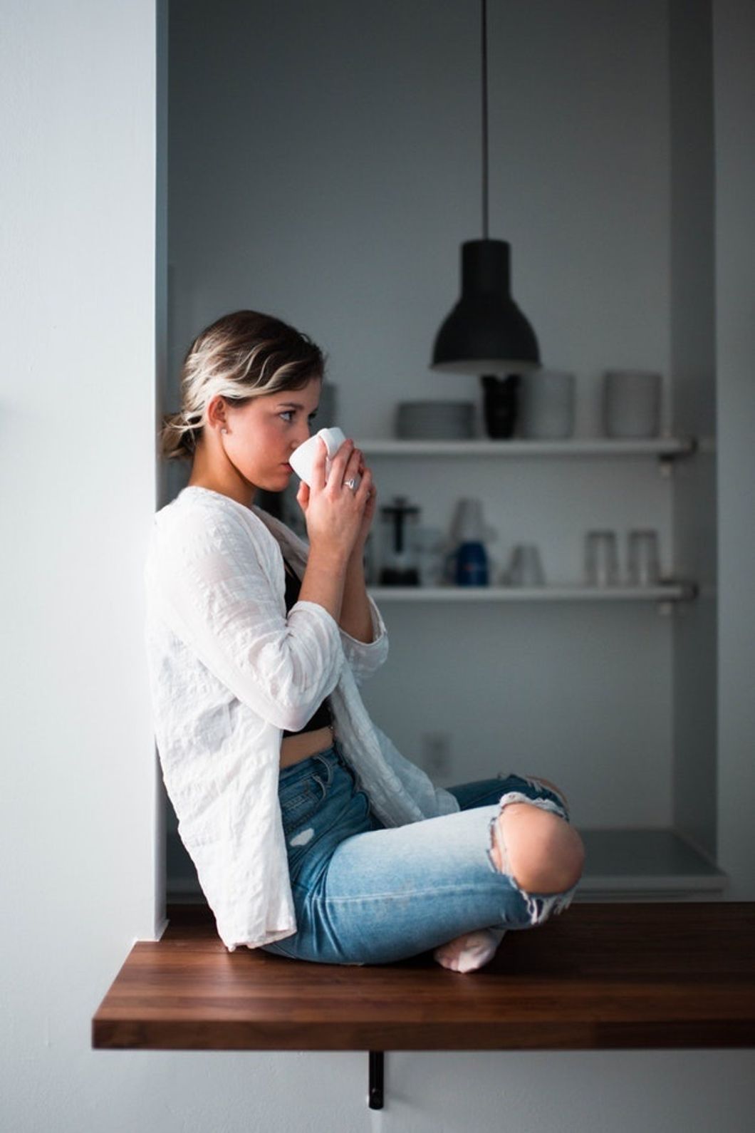 woman drinking coffee alone in kitchen