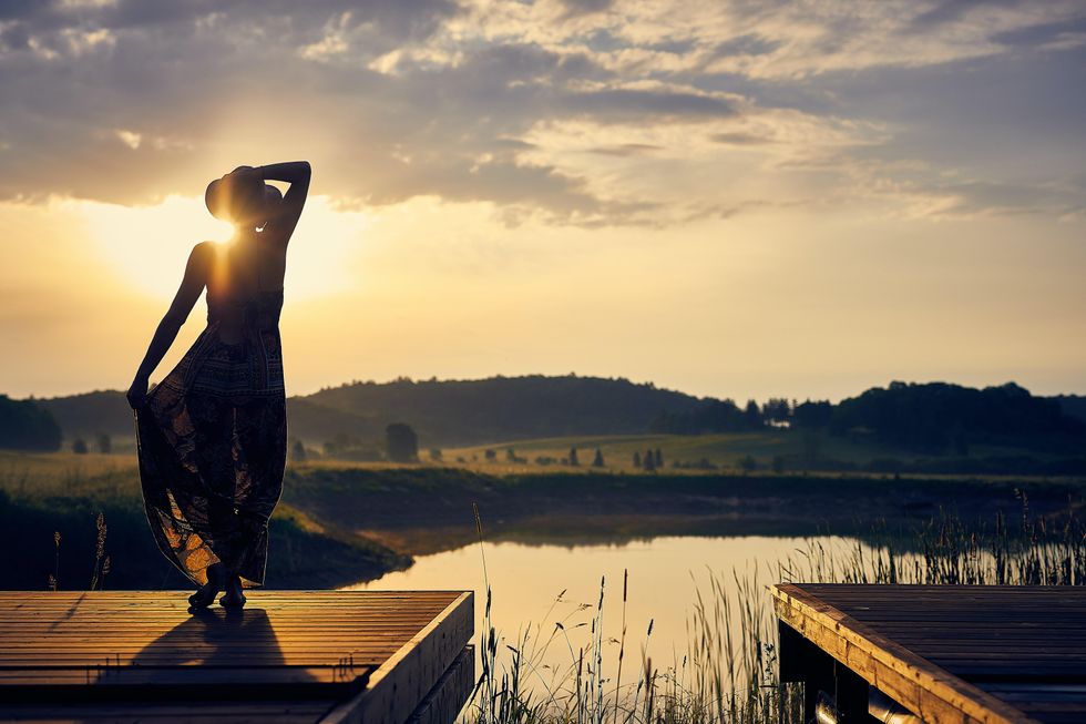 woman enjoys peaceful sunset by the lake