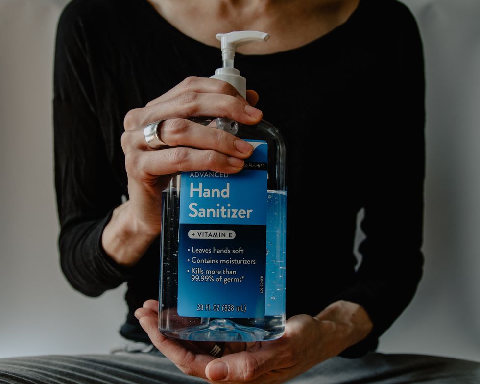 woman holding bottle of hand sanitizer