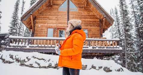 woman home for the holidays at a cabin during snowfall