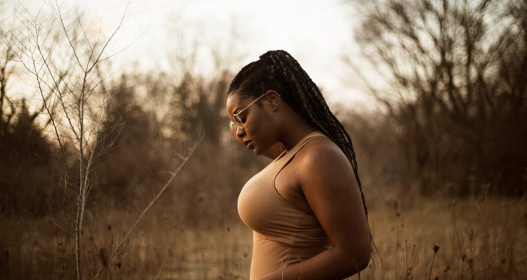 Woman in a field looking downward