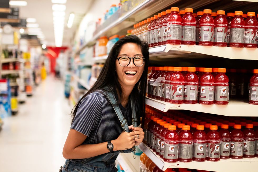 Woman laughing while standing beside Gatorade bottles. 