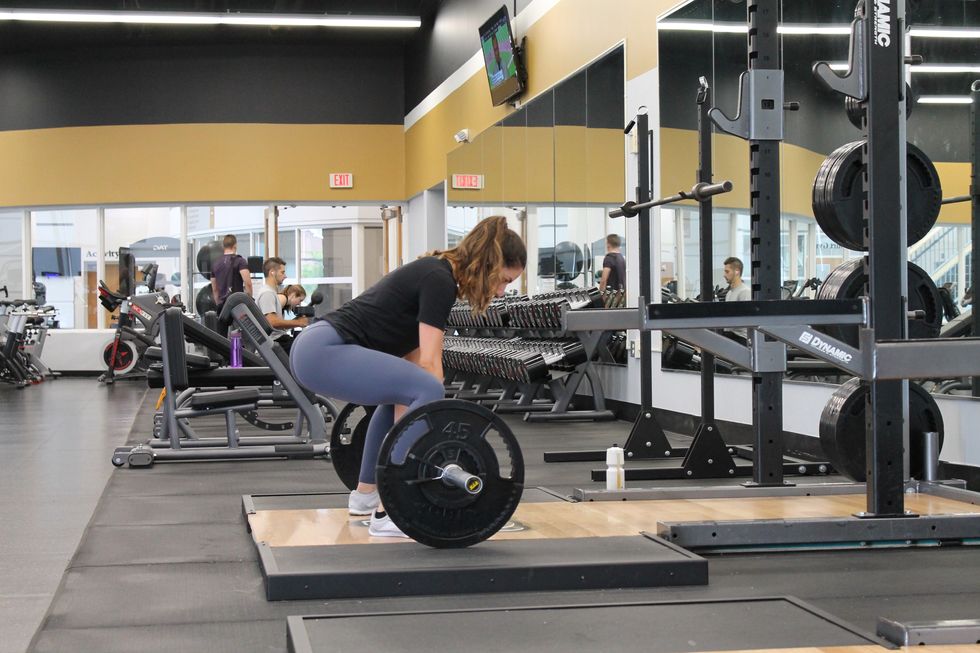woman lifts weights at local gym