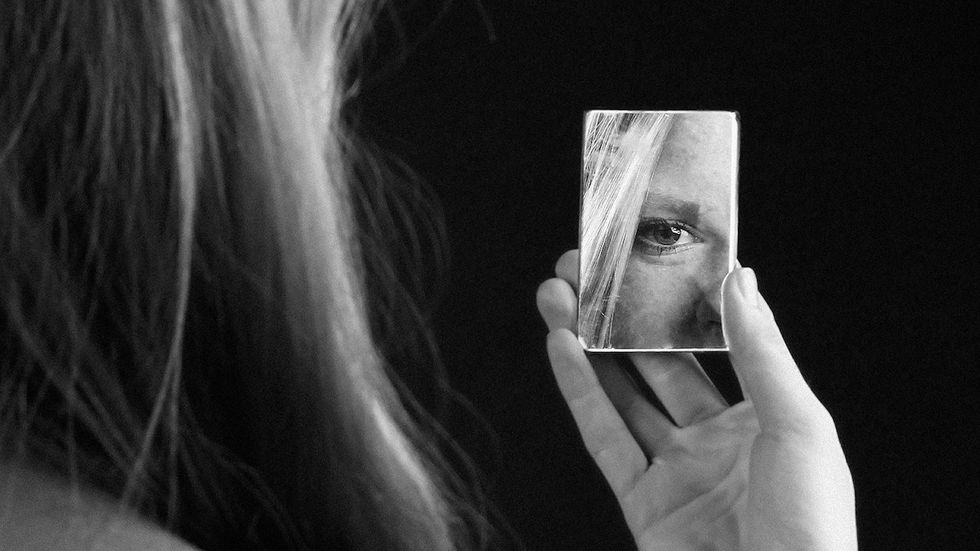 woman looking in mirror