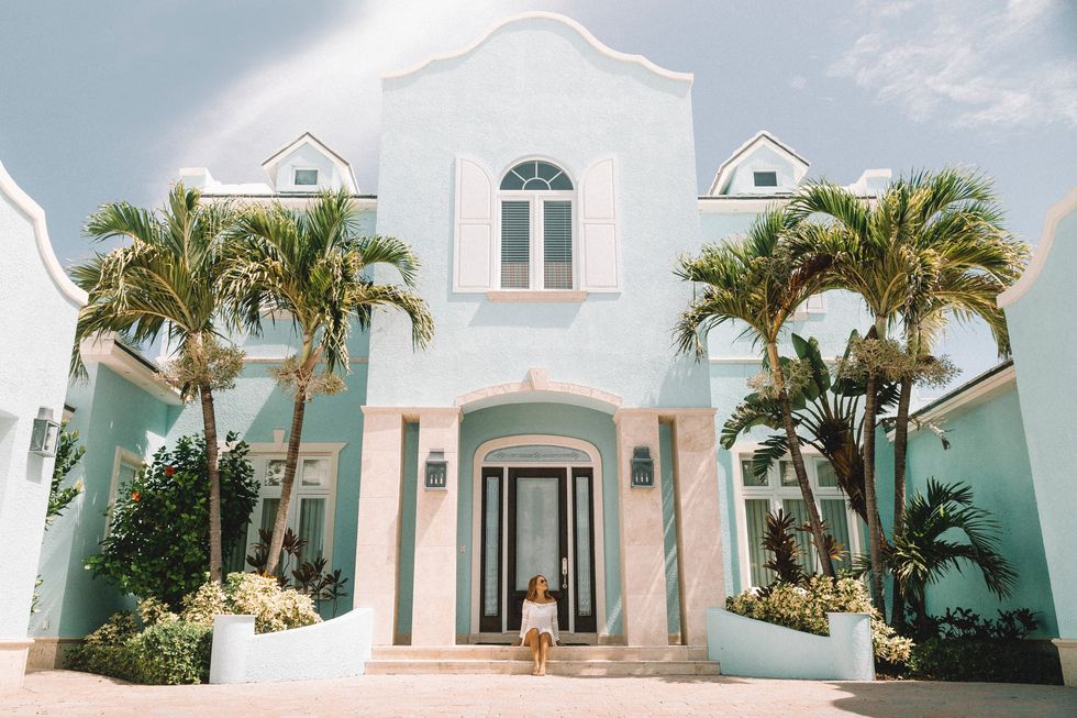 woman on front steps of California home with palm trees