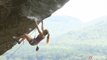 Woman rock climbing the side of a cliff