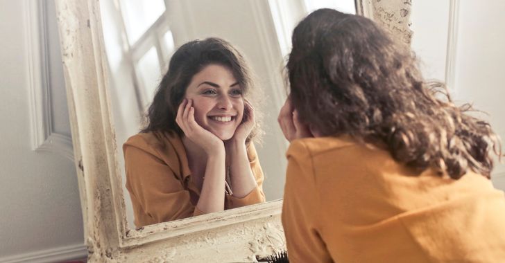 woman smiles in mirror