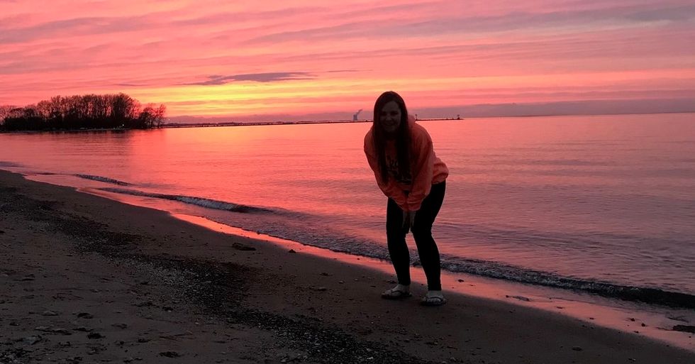 woman standing on beach in sunset