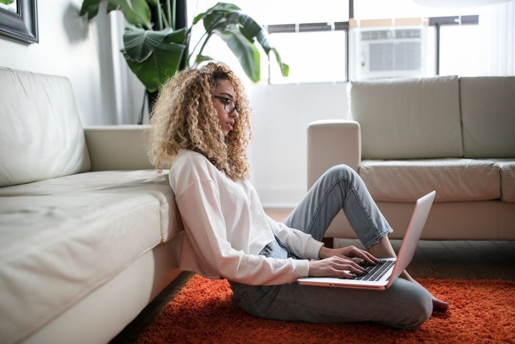 woman typing on laptop in living room