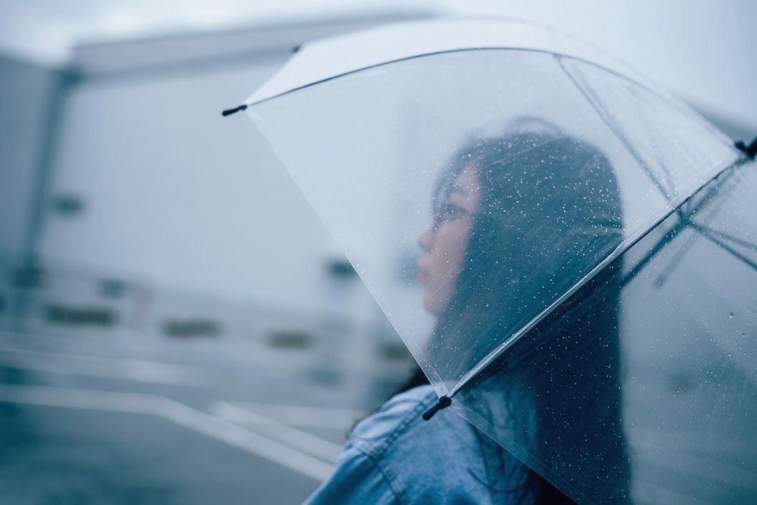 woman under umbrella outside in rain