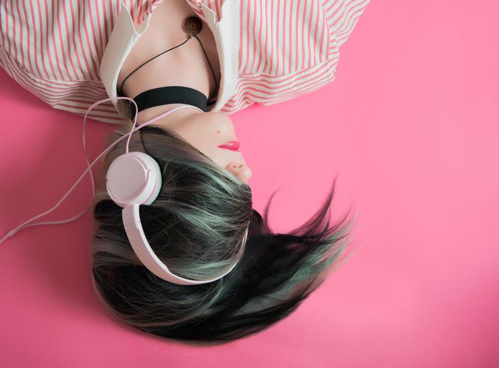 Woman wearing headphones listening to tunes to escape reality