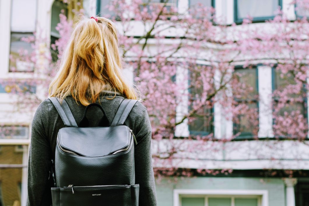 woman with backpack standing outside building