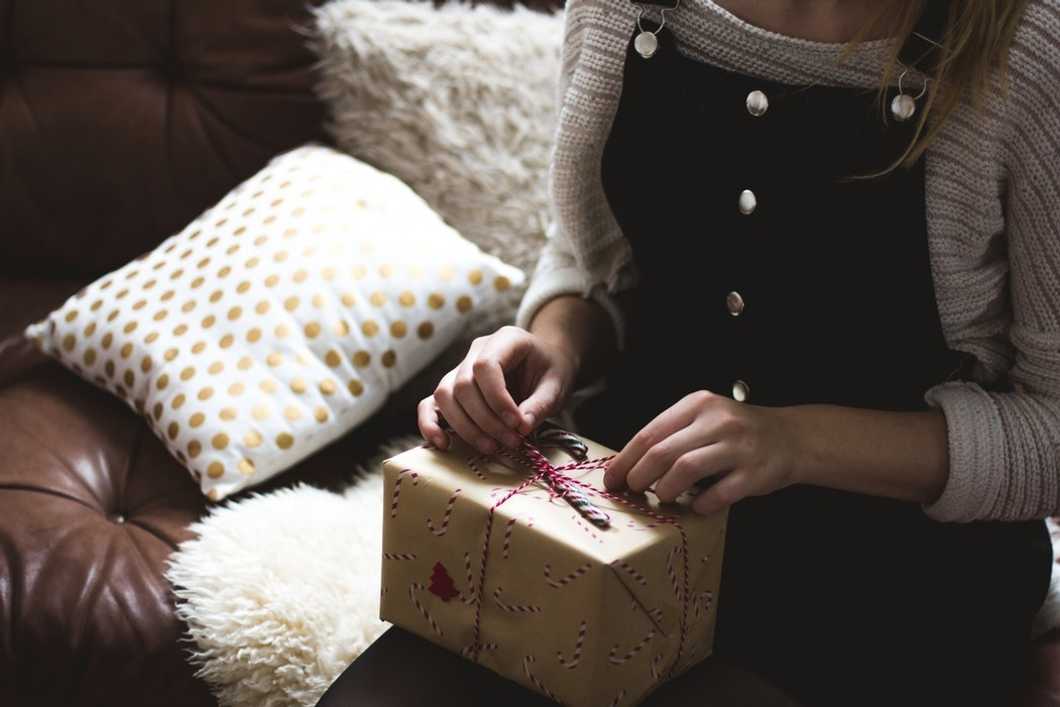 woman with christmas present on couch