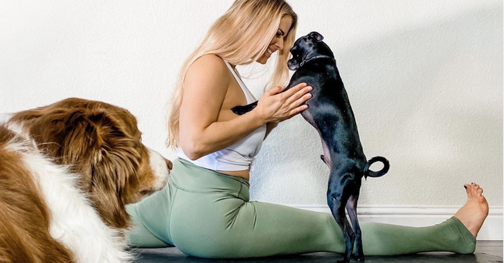 woman works out while playing with her dog