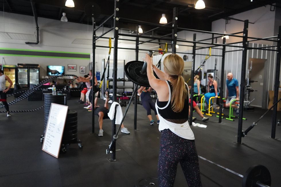 woman works out with strength training at a gym