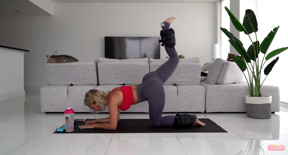 woman works out with yoga mat in living room