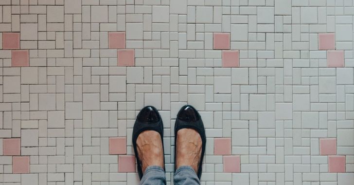 women feet on a tiled dirty floor