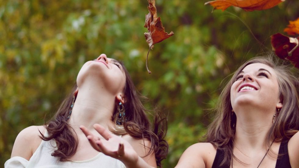 women throwing leaves