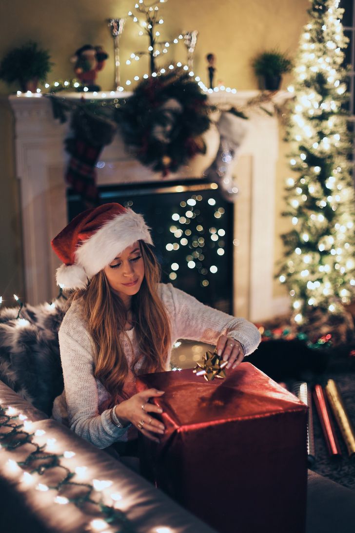 Young woman opening a Christmas gift